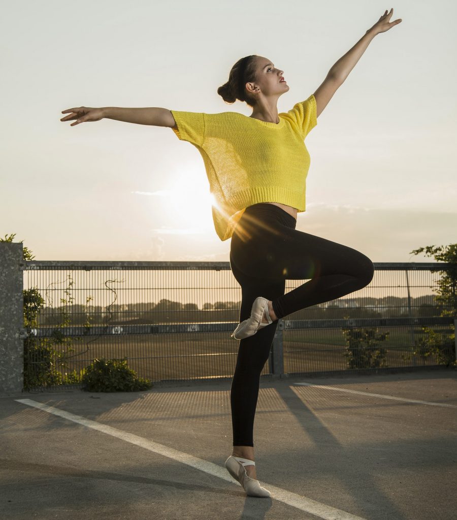 Young ballet dancer exercising on a parking level